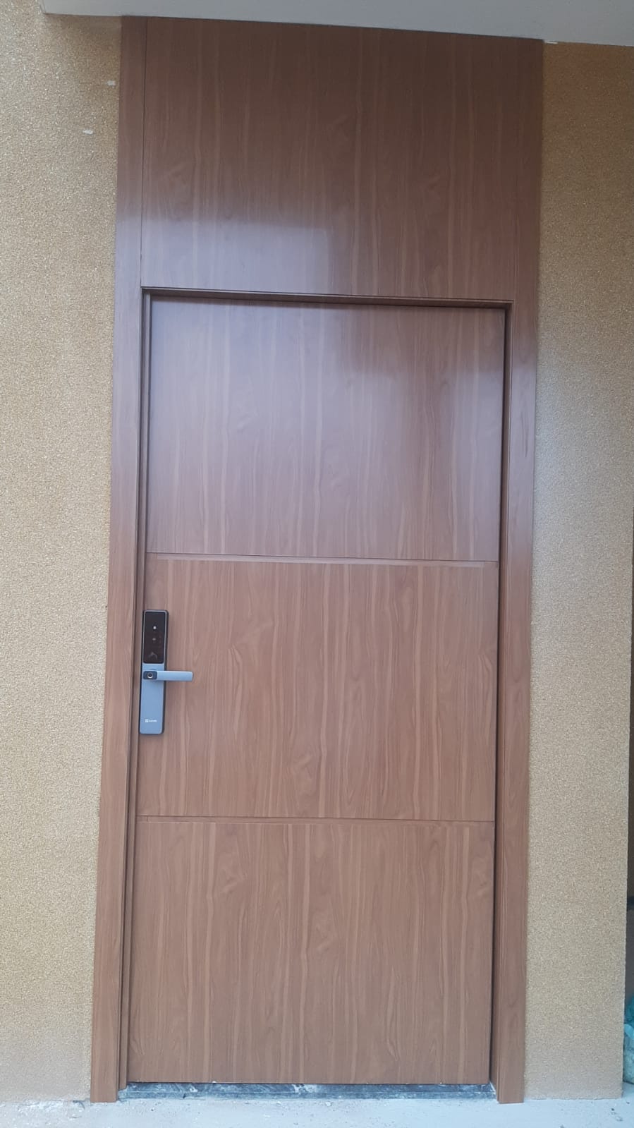Porta de entrada amadeirada com fechadura digital biométrica instalada em residência no Distrito Federal